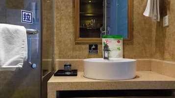 A bathroom with a white sink, a glass shower enclosure, a towel rack, and a mirror.