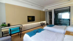 A hotel room with two beds, a desk, a chair, a TV, and a large window. - Jintai Hotel (Tongguan)