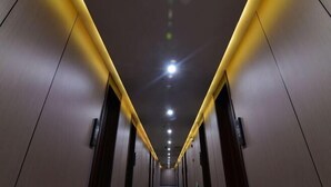 A long, narrow hallway with a central light fixture and doors on either side. - Jintai Hotel (Tongguan)