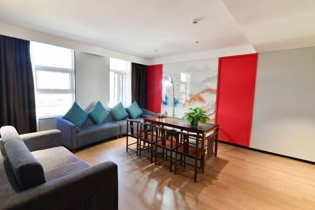 A modern living room with a sofa, a dining table, and chairs.