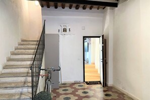 A staircase with a metal railing leading to a landing. A bicycle is parked on the landing. - CASA ILARIA - Bright apartment with a view in the historic center (Siena)