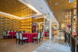 A spacious indoor area with tables and chairs, a wooden ceiling, and a glass wall. - Chenxi International Hotel (Xiapu)
