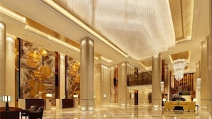 A spacious lobby with a high ceiling, large columns, and a chandelier. - Chenxi International Hotel (Xiapu)