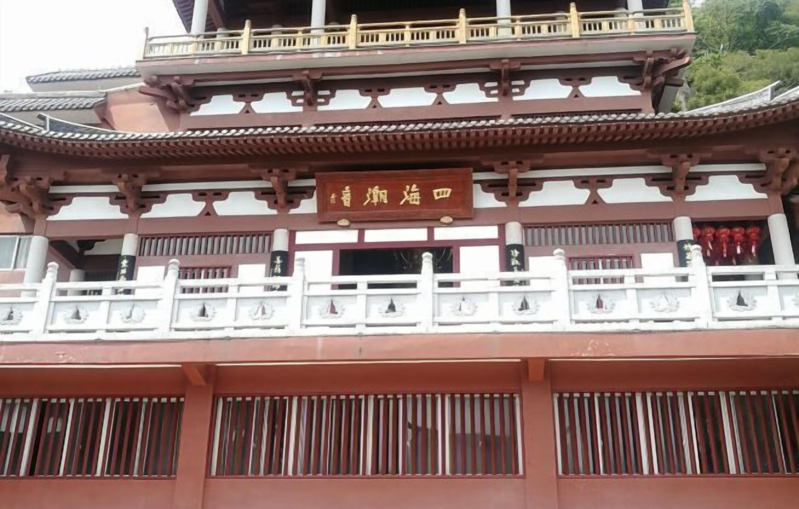 A traditional building with a signboard, wooden railings, and a tiled roof.