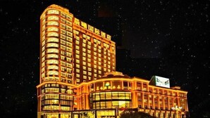 A multi-story hotel with a curved facade and illuminated windows. - Chenxi International Hotel (Xiapu)
