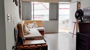 A modern bedroom with a bed, a desk, and a large window. - Beachfront - 2 Bedroom Suites + Air Conditioning, 2 Bathrooms, Living Room, Kitchen, 1 Garage, Wi-Fi and Bed Linen (SP)
