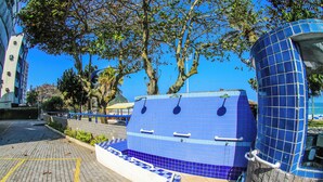 A blue-tiled structure with handrails, a brick-paved area, and trees in the background. - Beachfront - 2 Bedroom Suites + Air Conditioning, 2 Bathrooms, Living Room, Kitchen, 1 Garage, Wi-Fi and Bed Linen (SP)