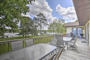 A deck with a table and chairs, overlooking a grassy area with trees and a body of water. - 'Cumberland Retreat' w/ Lakefront Yard & Dock (Cumberland)