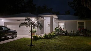 Une maison d'habitation avec un garage portant le numéro 3410, une allée et une pelouse bien entretenue.