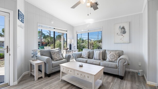 A spacious living room with a grey sofa set, a coffee table, and a ceiling fan. - Pet Friendly | Remodeled | Private Backyard | FLPCB37 (Panama City Beach)