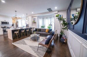 Relax in this stylish living space with a central island, sofa, and bench.