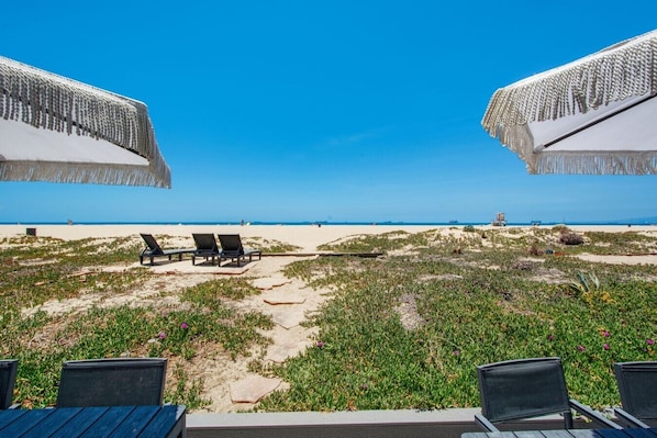A beach view with lounge chairs and umbrellas.