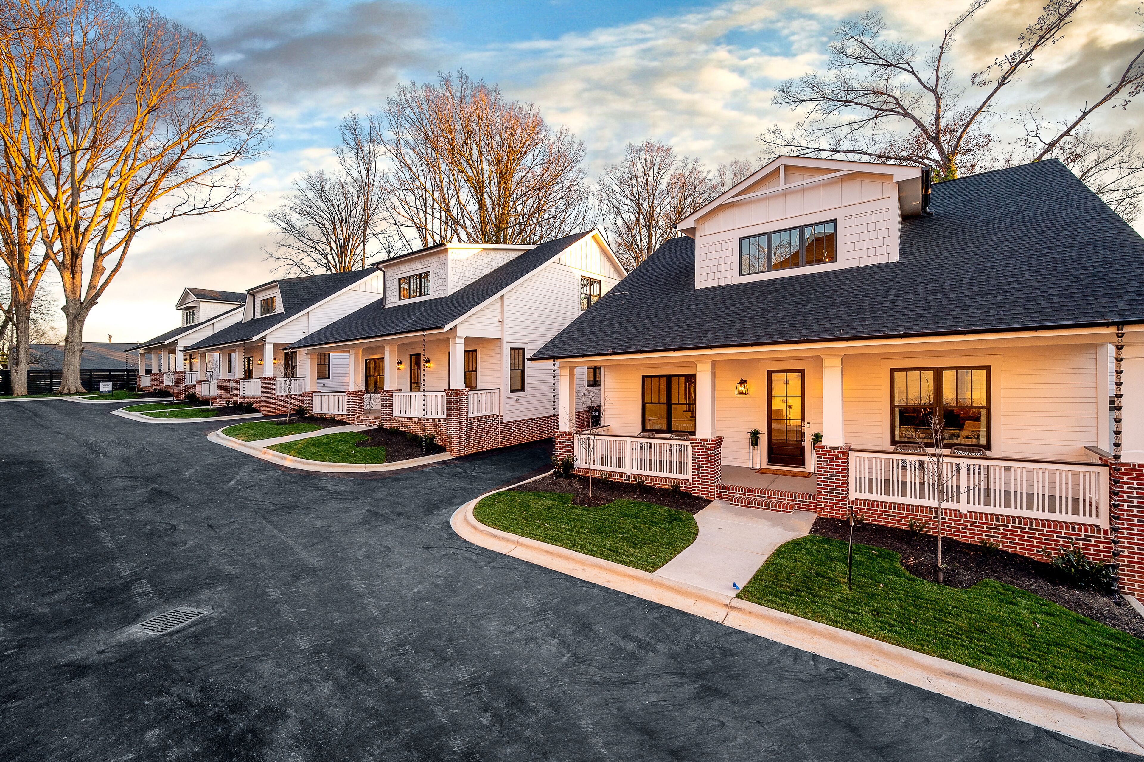 Une rangée de maisons modernes unifamiliales, dotées de garages attenants, d’une pelouse bien entretenue et d’une allée bien dégagée.
