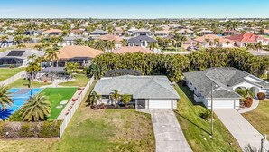 Un quartier résidentiel avec des maisons, une piscine et un court de tennis.