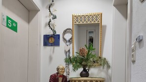 A hallway with a statue, a mirror, a plant, and a sign indicating room number 5. - Studio Apartment 'B + E Röck' with Private Balcony and Wi-Fi (Meckenbeuren)