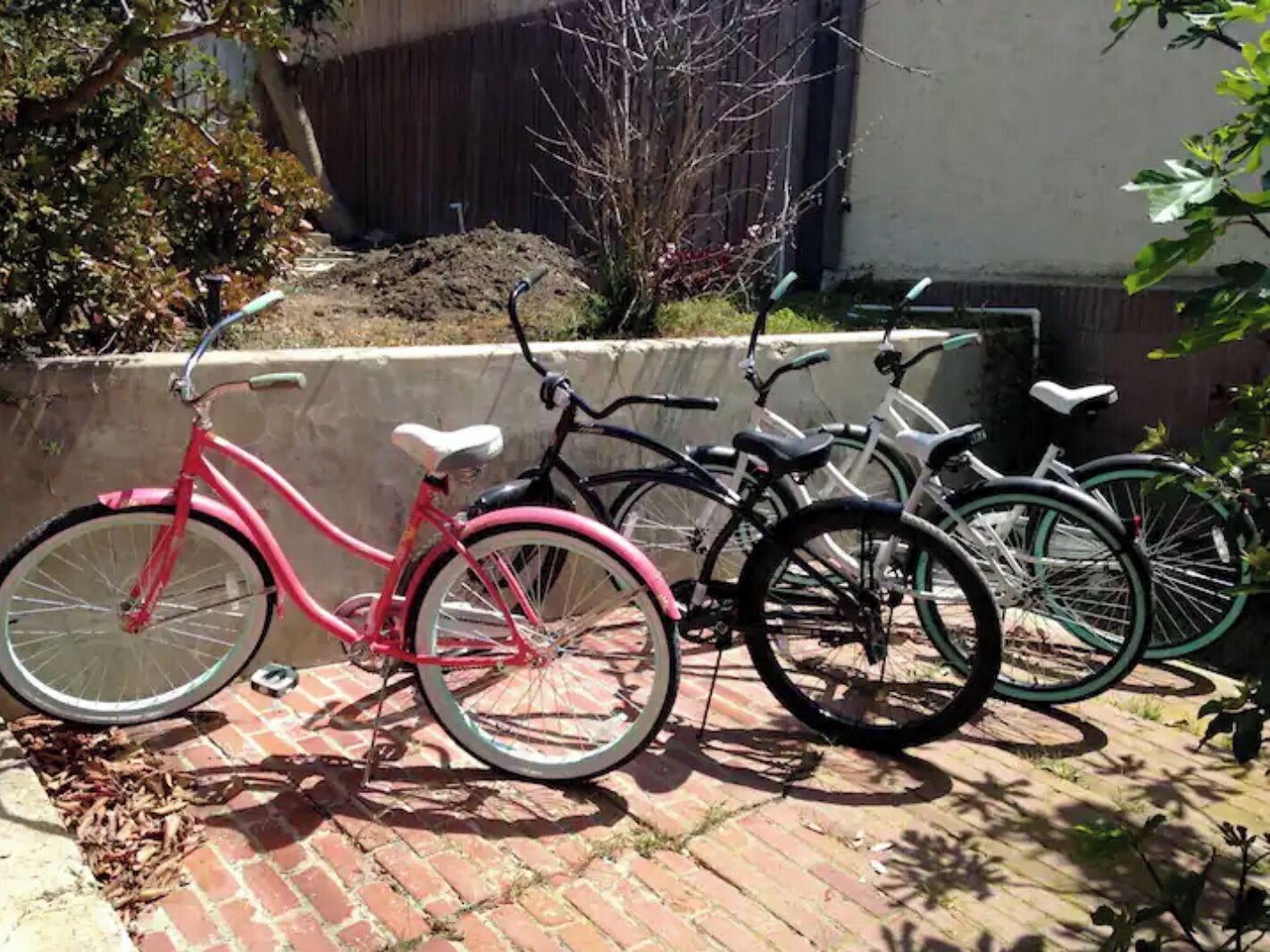 A row of bicycles parked on a brick patio.