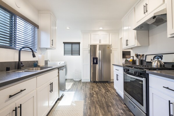 Enjoy cooking in this well-equipped kitchen with a double sink, refrigerator, oven, and stove.