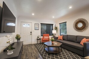 Relax in this stylish living room with a sofa, coffee table, and flat-screen TV.