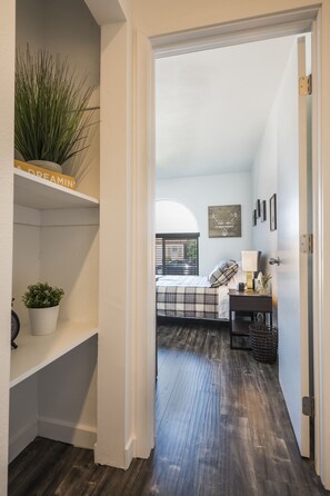 Enter a serene bedroom with a cozy bed, nightstand, and picture on the wall.
