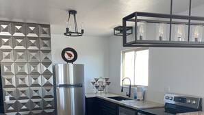 Eine moderne Küche mit Kochinsel, Edelstahlgeräten und einer geometrischen Spritzschutzwand.