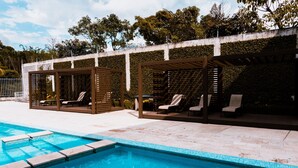 A swimming pool with lounge chairs and a pergola structure. - Corporate stays Urban flats (Pozos)