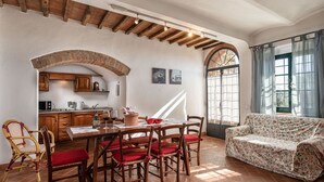Un coin repas chaleureux avec une table en bois, des chaises et un canapé.