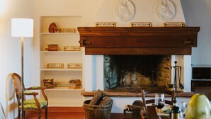Ein gemütliches Wohnzimmer mit Kamin, Bücherregalen und einer Kommode mit Gläsern.