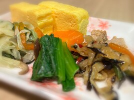 Un plato con una variedad de comida, incluyendo verduras y una rebanada de pan amarillo.