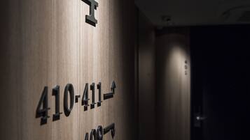 Pared de madera con números que indican los números de habitación 410-411 y 402-409.