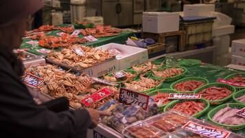 Un mercado de mariscos con diversos tipos de pescado y mariscos exhibidos en cestas y recipientes.