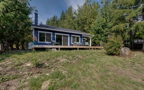 A modern house with a deck, surrounded by dense forest. - 47MF - WiFi - Lakefront - Sleeps 6 (Maple Falls)