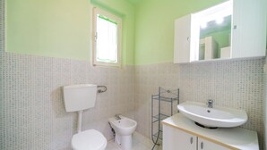 A bathroom with a toilet, bidet, and sink.