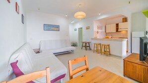 A modern apartment with a living room, dining area, and kitchen.