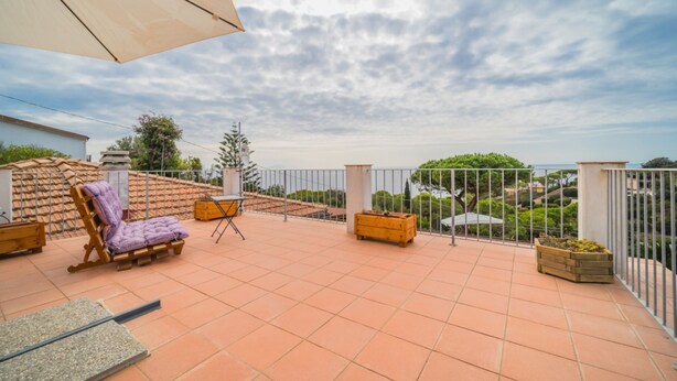 A terrace with tiled flooring, a wooden chair, a small table, and a large umbrella. - APPARTAMENTI RITA - MONO RITA N° 5 (Capoliveri)