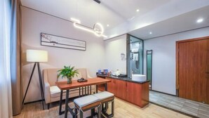 A modern hotel room with a dining area, a small kitchen, and a large mirror. - Mini Hotel (Huaihua)