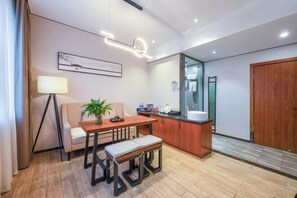 A modern hotel room with a dining area, a small kitchen, and a large mirror. - Mini Hotel (Huaihua)