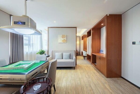 A hotel room with a pool table, a sofa, a wooden cabinet, and a ceiling fan. - Mini Hotel (Huaihua)