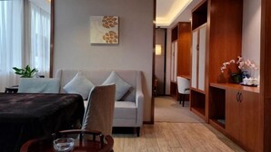 A modern living room with a sofa, a dining table, and a wooden cabinet. - Mini Hotel (Huaihua)