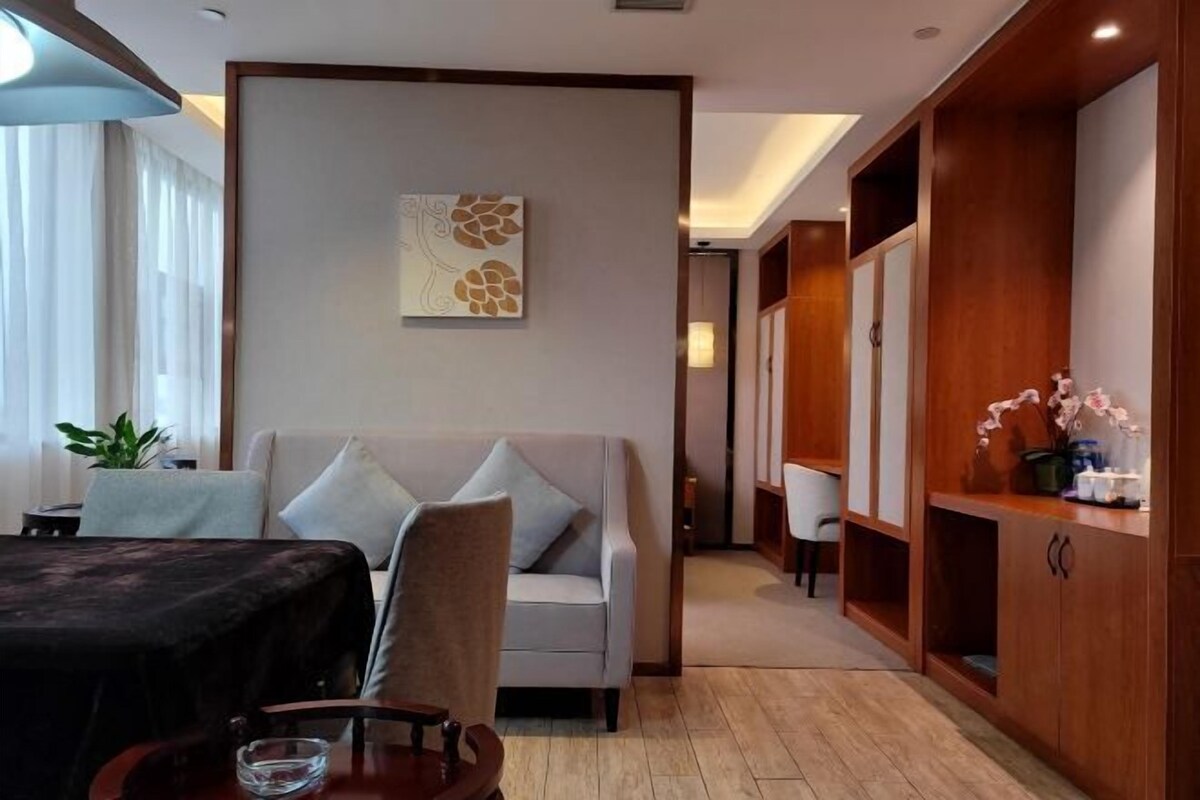 A modern living room with a sofa, a dining table, and a wooden cabinet.