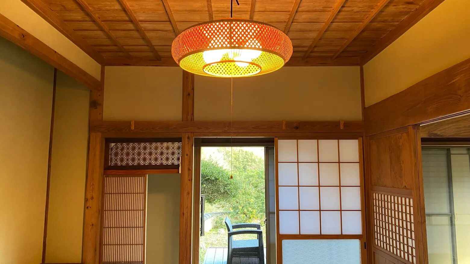 Et traditionelt japansk rum med tatamimåtter, en shoji skydedør og en hængende papirlampe.