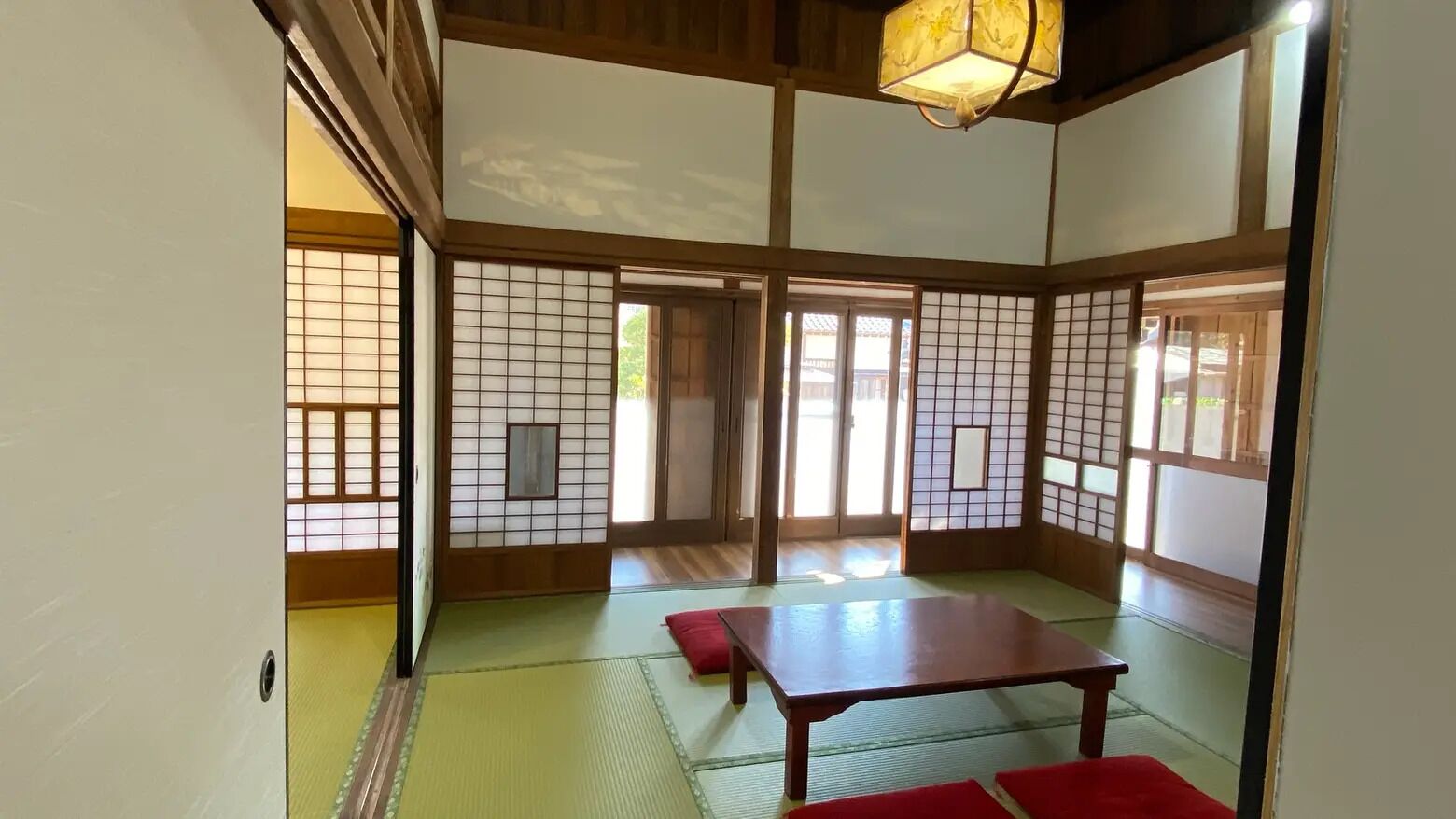 A traditional Japanese room with tatami flooring, sliding doors, and a low wooden table.