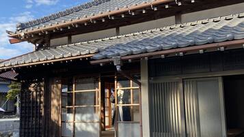 A traditional Japanese building with a tiled roof, wooden beams, and sliding doors.