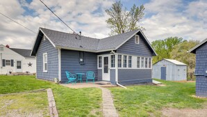 A two-story house with a covered porch and a small attached garage. - Homey Cottage with Sunroom & Smart TV! (Highland)