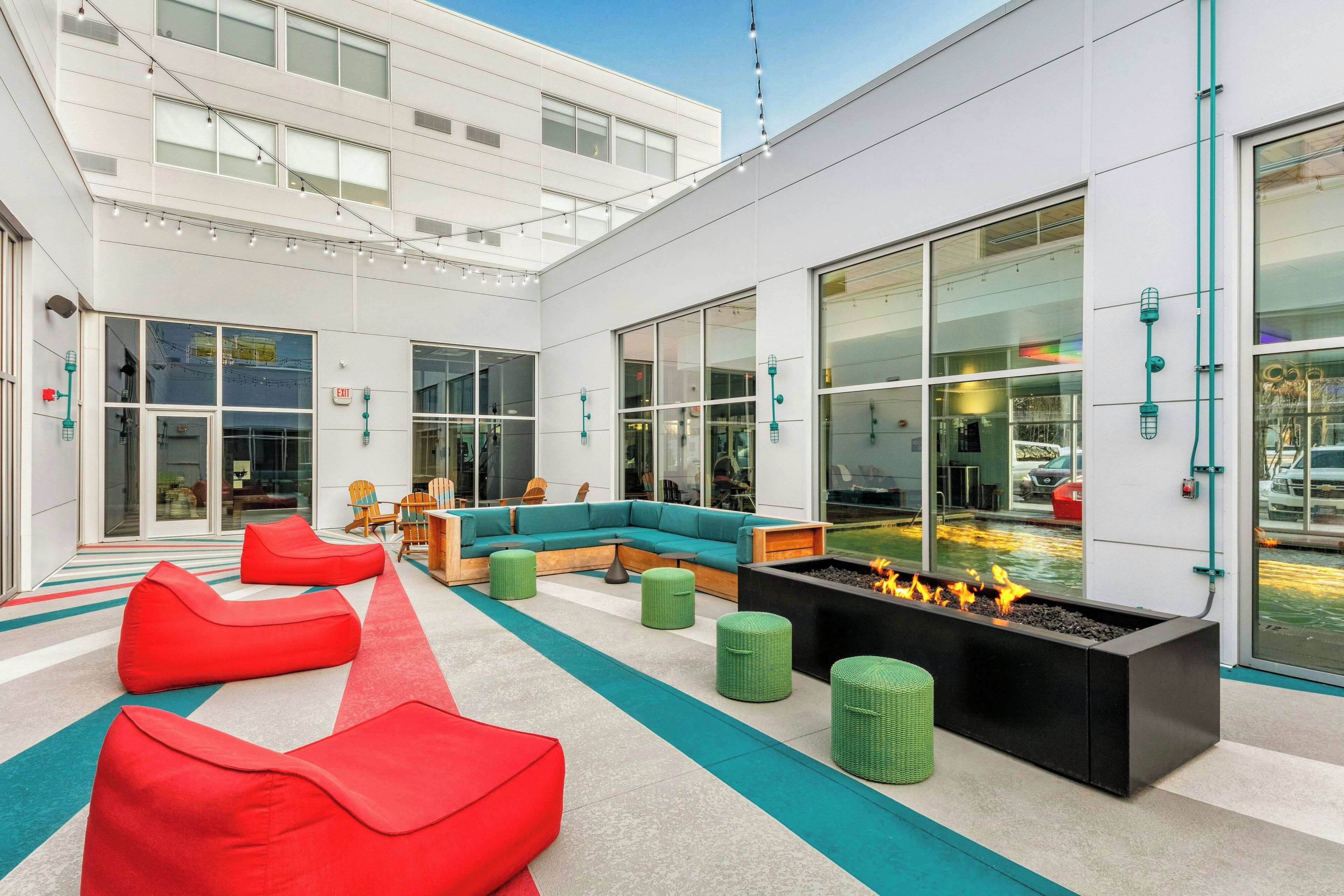 A modern lounge area with seating, a fire feature, and large windows.