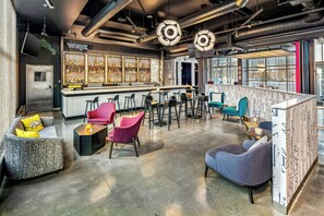 A modern bar area with seating, a bar counter, and a view of the outdoors. - Aloft by Marriott Anchorage (Anchorage)