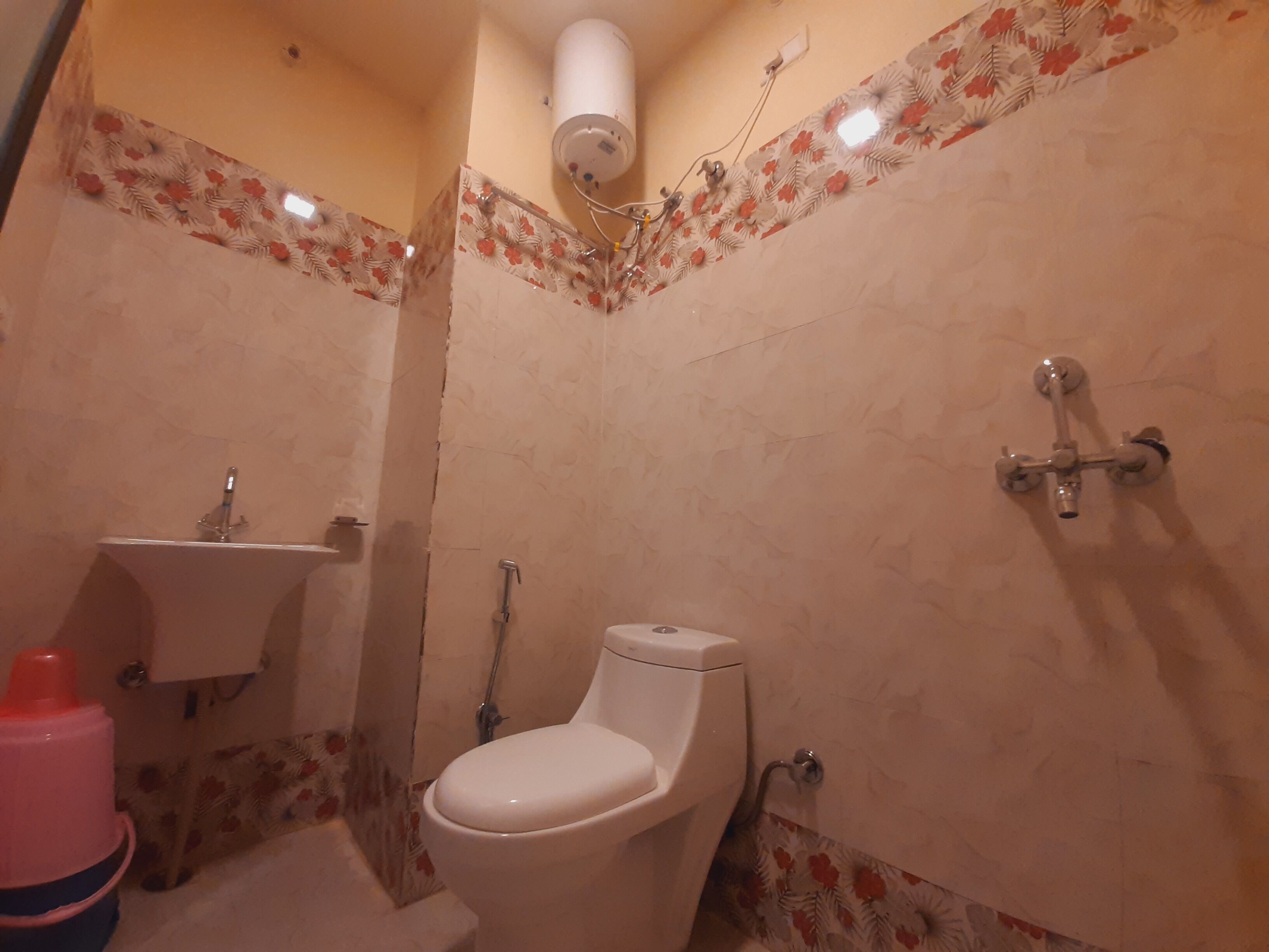 A small bathroom with a toilet, sink, and shower.