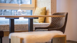 Un rincón acogedor con un sillón mullido, una mesa de madera y una ventana con vistas al exterior.