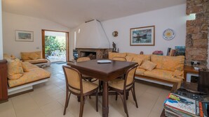 Un salon comprenant une table à manger, deux canapés et une cheminée.