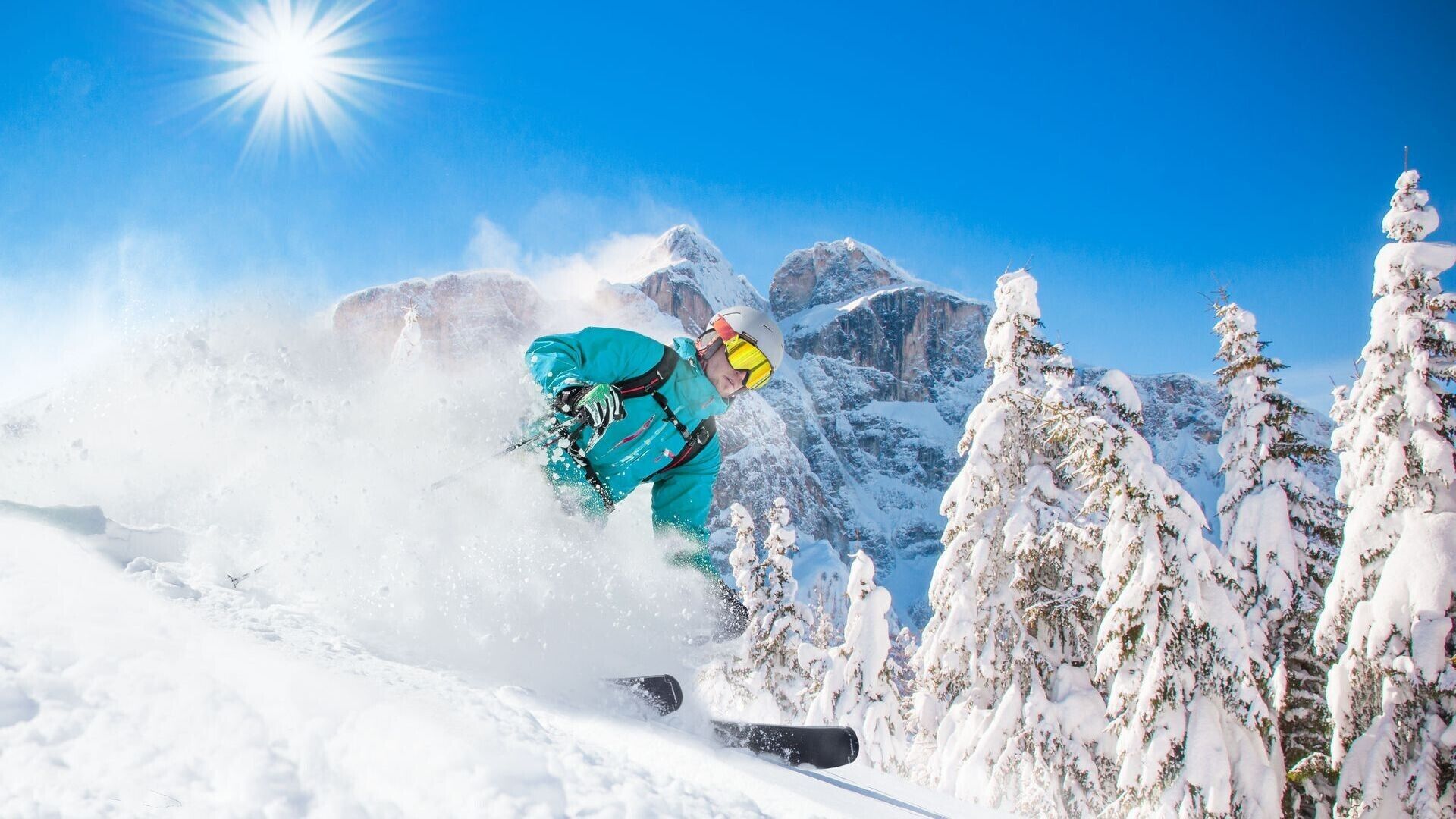 A snowboarder in motion, surrounded by snow-covered trees and mountains.