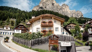 A mountain lodge with a wooden facade, balconies with flower boxes, and a sign reading 'Lisuara Apartments.' - Apartment 'Lisüra Boè' with Mountain View and Wi-Fi (Corvara)